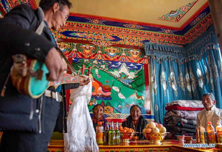 A villager relocated from poverty-stricken area plays six-string guitar to celebrate farmers' New Year in his new house in Gajilin Village of Chaqiug Township in Sa'gya County of Xigaze, southwest China's Tibet Autonomous Region, Jan. 14, 2021. Residents who were relocated from poverty-stricken area celebrate the farmers' New Year in their new homes in Gajilin Village. In Xigaze and other farming regions of Tibet, people celebrate New Year on the 1st day of the twelfth month of the Tibetan lunar calendar. According to local farming tradition, spring ploughing season always begins as the fall of New Year, thus celebrating one month earlier is to meet the needs of local agriculture. Xigaze City is regarded as a granary of Tibet. (Xinhua/Sun Fei)