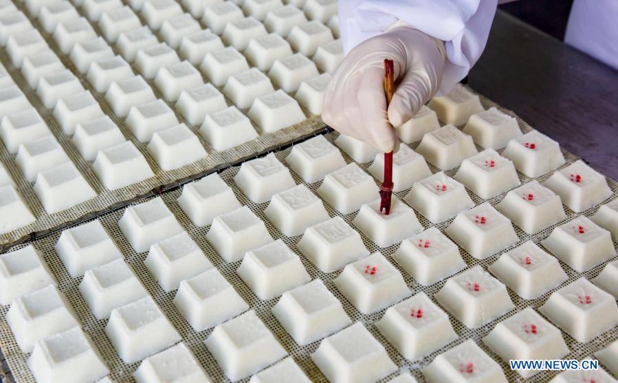 A worker makes rice cakes at a food factory in Zhuangzhi Village of Haian, east China's Jiangsu Province, Jan. 16, 2021. Workers in Haian are busy making rice cakes to meet customers' growing demands as the Spring Festival approaches. (Photo by Xiang Zhonglin/Xinhua)