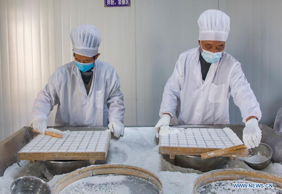 Workers make rice cakes at a food factory in Zhuangzhi Village of Haian, east China's Jiangsu Province, Jan. 16, 2021. Workers in Haian are busy making rice cakes to meet customers' growing demands as the Spring Festival approaches. (Photo by Xiang Zhonglin/Xinhua)