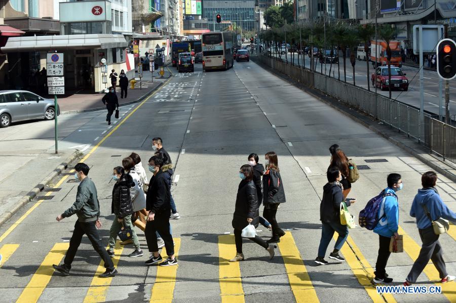 People wearing face masks walk on the street in south China's Hong Kong, Jan. 18, 2021. Hong Kong's Center for Health Protection (CHP) reported 107 additional confirmed cases of COVID-19 on Monday, a new high in about one month. The new cases included 102 local infections and five imported ones, taking its total tally to 9,664. More than 40 of the new local cases were untraceable and there were about 50 cases tested positive preliminarily, according to a CHP press briefing. (Xinhua/Lo Ping Fai)