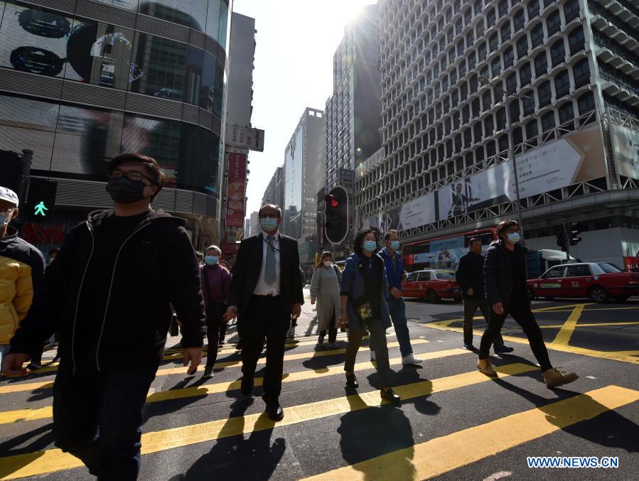People wearing face masks walk on the street in south China's Hong Kong, Jan. 18, 2021. Hong Kong's Center for Health Protection (CHP) reported 107 additional confirmed cases of COVID-19 on Monday, a new high in about one month. The new cases included 102 local infections and five imported ones, taking its total tally to 9,664. More than 40 of the new local cases were untraceable and there were about 50 cases tested positive preliminarily, according to a CHP press briefing. (Xinhua/Lo Ping Fai)
