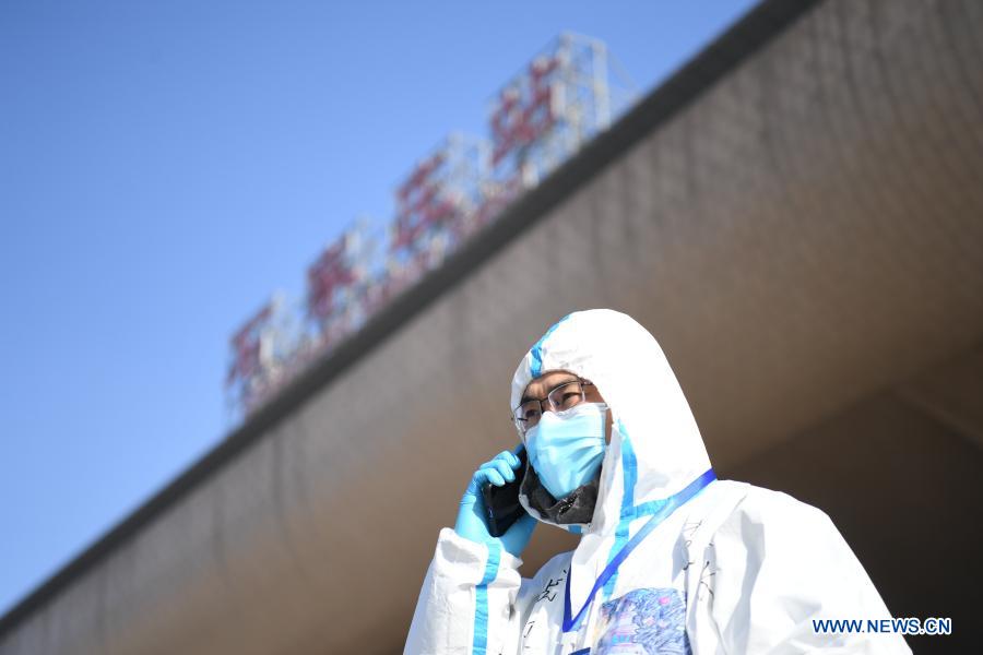 Ride-hailing driver volunteer Fan Yuejia arranges free ride services over the phone at Shijiazhuang Railway Station amid the COVID-19 pandemic in Shijiazhuang, north China's Hebei Province, Jan. 18, 2021. As all other public transportation services in Shijiazhuang were suspended for COVID-19 prevention and control purposes, local ride-hailing drivers have stepped forward and volunteered to help. Headed by 36-year-old Fan Yuejia, the 800-strong team of volunteer drivers is providing free rides to travellers arriving in the city in the run-up to the Chinese Lunar New Year. (Xinhua/Zhu Xudong)