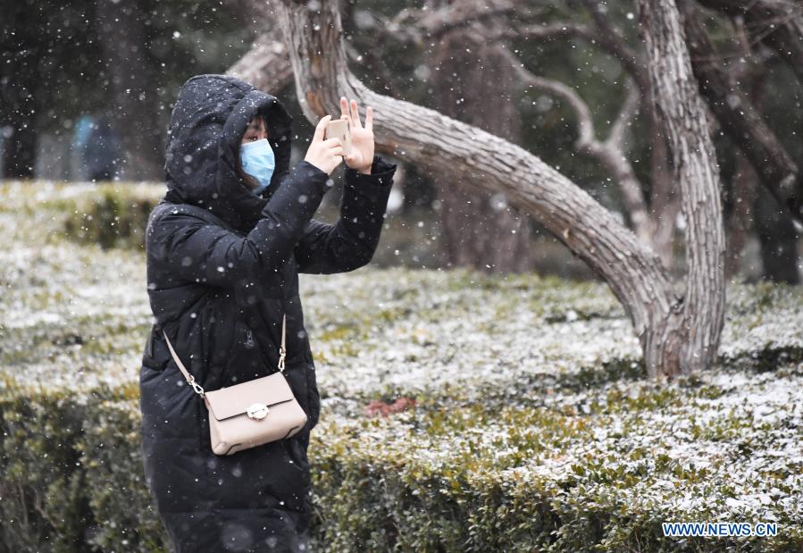 A woman takes photos in the snow in Beijing, capital of China, Jan. 19, 2021. (Xinhua/Ren Chao)