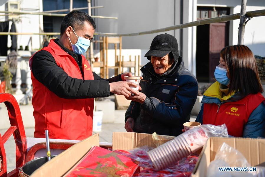 Volunteers serve free Laba porridge to an elderly man at Zhashuwu Village in Huzhou, east China's Zhejiang Province, Jan. 19, 2021. The Laba Festival, literally the eighth day of the 12th lunar month, is considered a prelude to the Spring Festival, or Chinese Lunar New Year. (Xinhua/Huang Zongzhi)