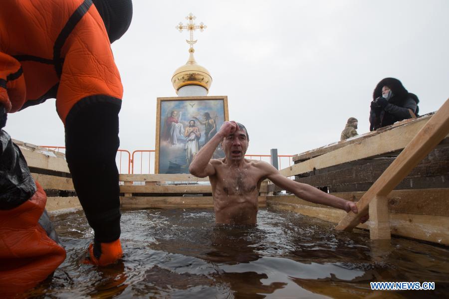 A man bathes in icy water during the Orthodox Epiphany celebrations in St. Petersburg, Russia, Jan. 19, 2021. (Photo by Irina Motina/Xinhua)