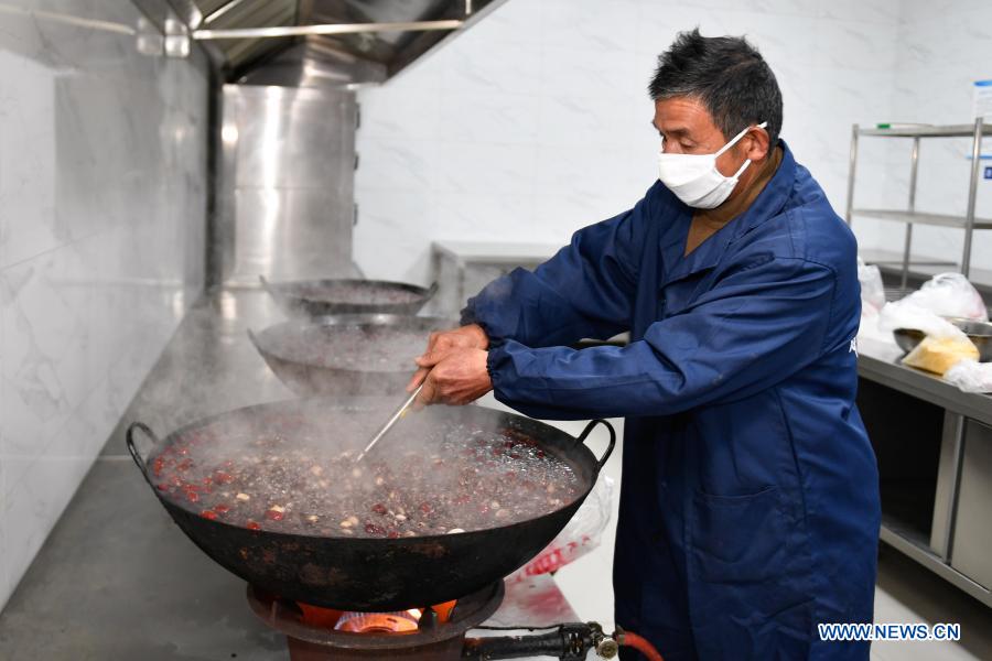 A volunteer prepares free Laba porridge for the elderly at Zhashuwu Village in Huzhou, east China's Zhejiang Province, Jan. 19, 2021. The Laba Festival, literally the eighth day of the 12th lunar month, is considered a prelude to the Spring Festival, or Chinese Lunar New Year. (Xinhua/Huang Zongzhi)