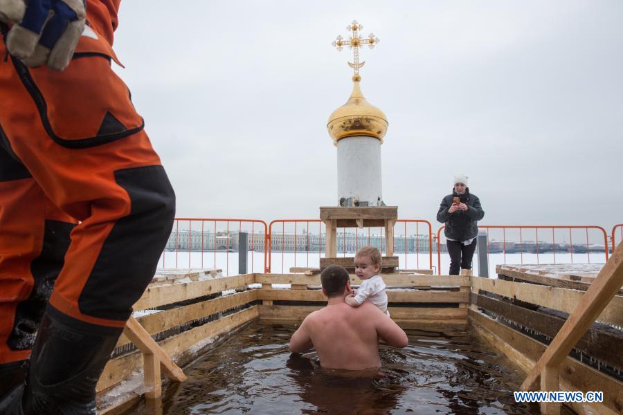 A man and his child bathe in icy water during the Orthodox Epiphany celebrations in St. Petersburg, Russia, Jan. 19, 2021. (Photo by Irina Motina/Xinhua)