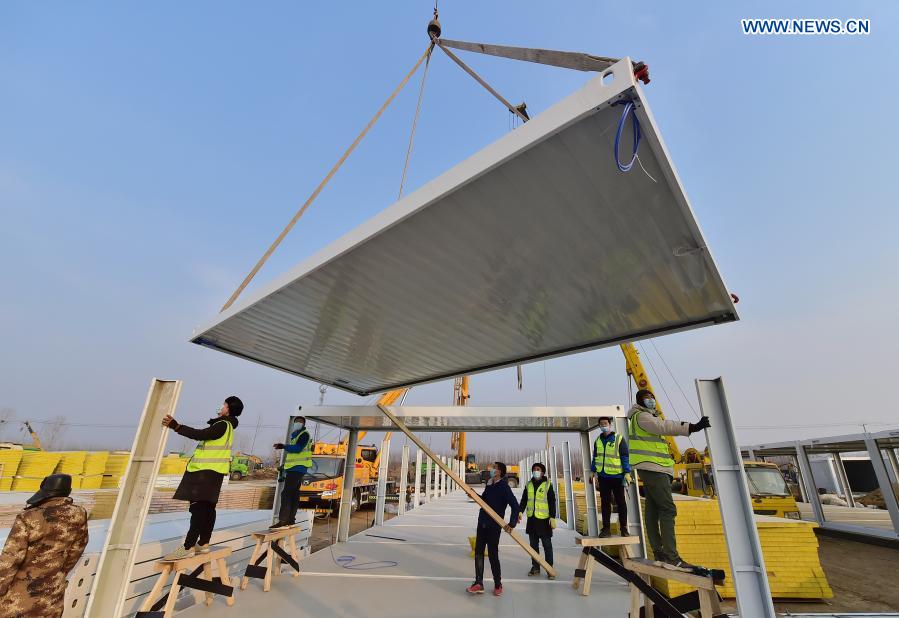 Workers work at the construction site of the Huangzhuang Apartment quarantine center in Shijiazhuang, north China's Hebei Province, Jan. 20, 2021. Located at the junction of Zhengding County and Gaocheng District in Shijiazhuang, the Huangzhuang Apartment COVID-19 quarantine center project has an area of 658 mu (about 43.87 hectares), and a capacity of 4,156 rooms, which is used to accommodate close contacts and sub-close contacts of confirmed COVID-19 patients. (Xinhua/Yang Shiyao)