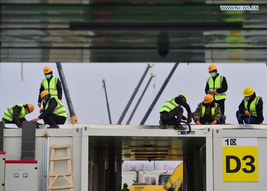 Workers work at the construction site of the Huangzhuang Apartment quarantine center in Shijiazhuang, north China's Hebei Province, Jan. 20, 2021. Located at the junction of Zhengding County and Gaocheng District in Shijiazhuang, the Huangzhuang Apartment COVID-19 quarantine center project has an area of 658 mu (about 43.87 hectares), and a capacity of 4,156 rooms, which is used to accommodate close contacts and sub-close contacts of confirmed COVID-19 patients. (Xinhua/Yang Shiyao)