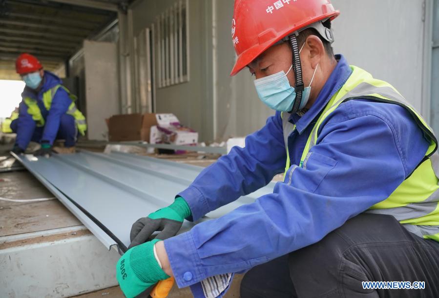 Luo Chang'an(R) and Luo Yandong work at the construction site of the Huangzhuang Apartment quarantine center in Shijiazhuang, north China's Hebei Province, Jan. 21, 2021. Luo Yandong, a 22-year-old junior of Wuhan Technical College of Communications, started his internship at Second Engineering Co., Ltd. of China Railway First Group three months ago. He now participates in the construction of Huangzhuang Apartment quarantine center where his father Luo Chang'an is also a worker. Located at the junction of Zhengding County and Gaocheng District in Shijiazhuang, the Huangzhuang Apartment COVID-19 quarantine center project covers an area of 658 mu (about 43.87 hectares) with a capacity of 4,156 rooms, which will be used to accommodate close contacts and sub-close contacts of confirmed COVID-19 patients. (Xinhua/Yang Shiyao)