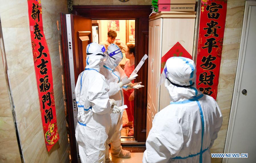 Medical workers check COVID-19 screening information at a residential area in Dongchang District of Tonghua, northeast China's Jilin Province, Jan. 25, 2021. Tonghua on Monday launched the third round of citywide nucleic acid testing. (Xinhua/Xu Chang)