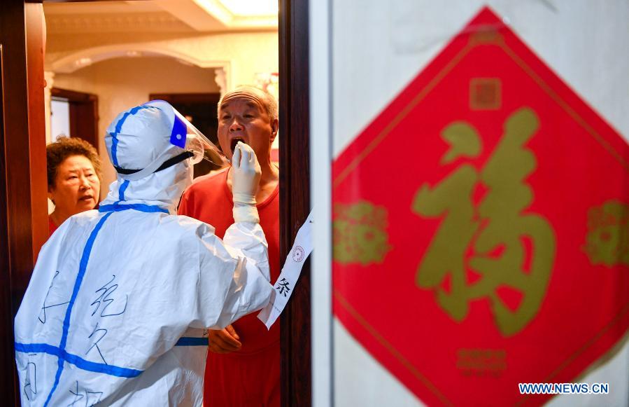 A medical worker collects swab samples for COVID-19 screening at a residential area in Dongchang District of Tonghua, northeast China's Jilin Province, Jan. 25, 2021. Tonghua on Monday launched the third round of citywide nucleic acid testing. (Xinhua/Xu Chang)