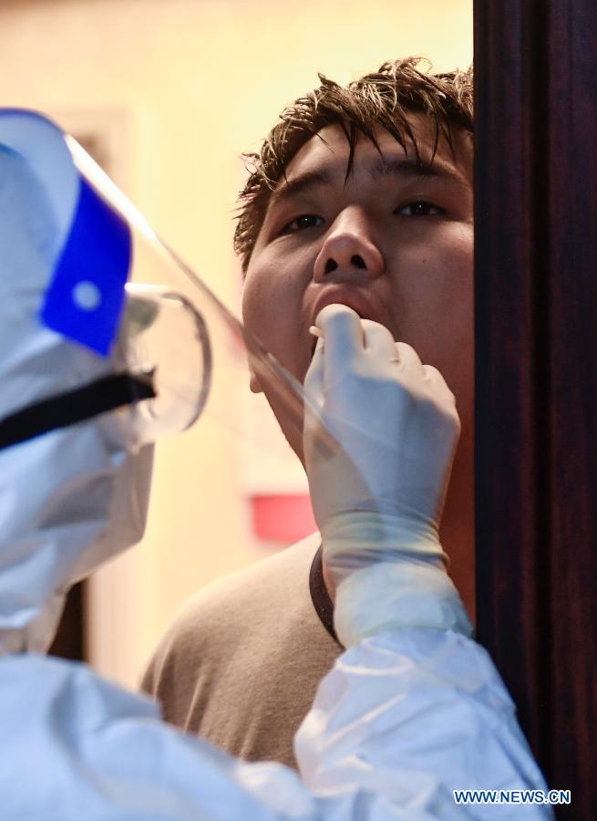 A medical worker collects swab samples for COVID-19 screening at a residential area in Dongchang District of Tonghua, northeast China's Jilin Province, Jan. 25, 2021. Tonghua on Monday launched the third round of citywide nucleic acid testing. (Xinhua/Xu Chang)