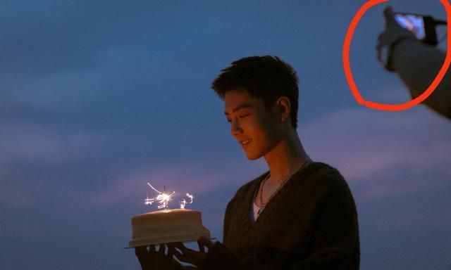 肖战手捧蛋糕,右上角的机器暴露了,可以看出