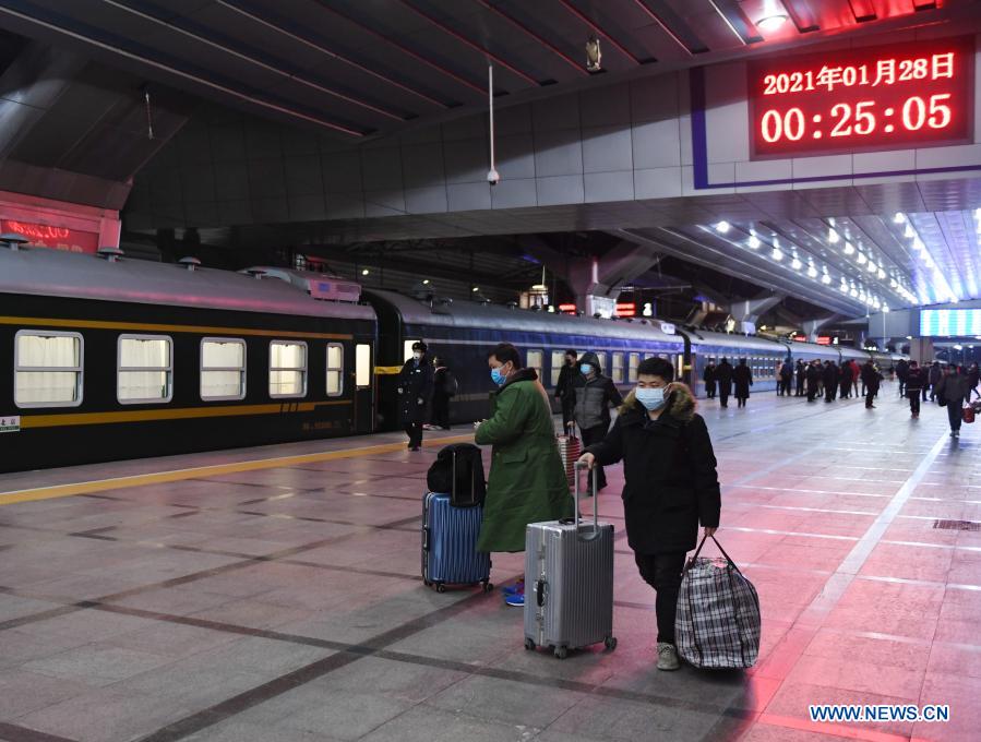 Passengers walk to board their train at the Beijing Railway Station, in Beijing, capital of China, Jan. 28, 2021. The Spring Festival travel rush, known as the world's largest annual human migration, lasts 40 days from Jan. 28 to March 8 this year. (Xinhua/Zhang Chenlin)