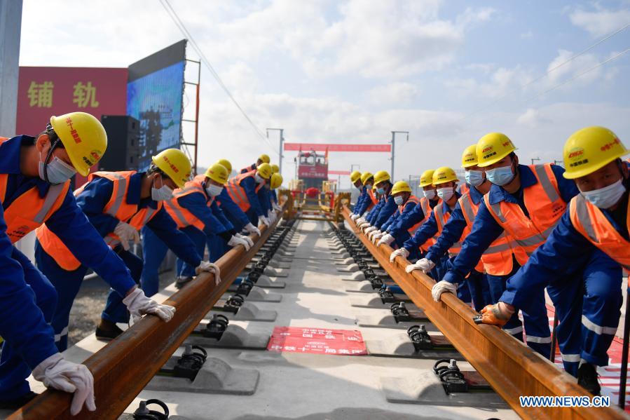 Workers lay tracks for 1st Chinese highspeed railway controlled by