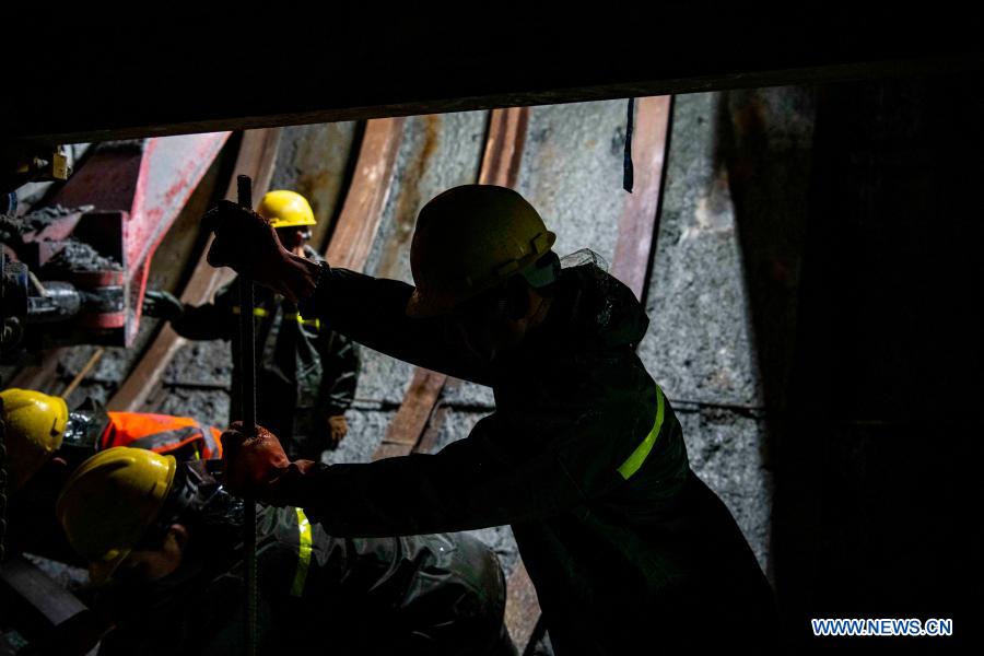 Workers are busy at the construction site of Tianshan Shengli tunnel in northwest China's Xinjiang Uygur Autonomous Region, Feb. 4, 2021. Tianshan Shengli tunnel, with a total length of about 22 kilometers, is currently the longest highway tunnel under construction in China. Started in 2020, the tunnel, a six-year project on the Urumqi-Yuli highway, passes through a cold and high altitude zone, with harsh climate and geological condition. After completion and opened to traffic, it will provide safer and more convenient travel to the passengers and promote local economic and social development. (Xinhua/Hu Huhu)