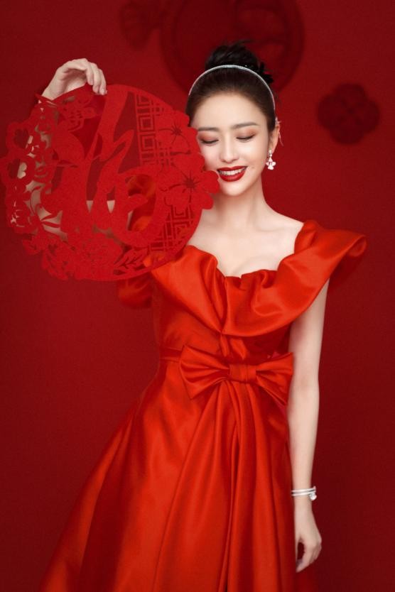 照片中佟丽娅身穿红色缎面长裙,梳着可爱的丸子头,精致大气的妆容配上