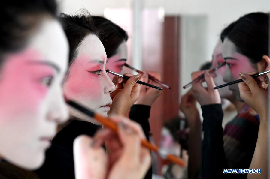 Dancers put on makeup at Zhengzhou Song and Dance Theater in Zhengzhou, central China's Henan Province, Feb. 20, 2021. Fourteen dancers from Zhengzhou Song and Dance Theater have been very busy since the dancing they performed went viral online. The performance, named Banquet of Tang Palace, was staged at the Spring Festival gala of Henan Province. Brilliantly choreographed and acted, the dancing has almost brought ancient dancing figurines of the Tang Dynasty (618-907) alive. The performance Banquet of Tang Palace, inspired by the dancing figurines displayed at a museum, tells a story about the life of female musicians during the Tang Dynasty. 