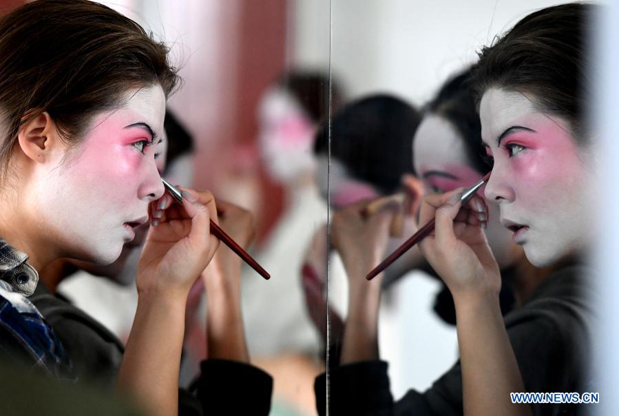 Dancers put on makeup at Zhengzhou Song and Dance Theater in Zhengzhou, central China's Henan Province, Feb. 20, 2021. Fourteen dancers from Zhengzhou Song and Dance Theater have been very busy since the dancing they performed went viral online. The performance, named Banquet of Tang Palace, was staged at the Spring Festival gala of Henan Province. Brilliantly choreographed and acted, the dancing has almost brought ancient dancing figurines of the Tang Dynasty (618-907) alive. The performance Banquet of Tang Palace, inspired by the dancing figurines displayed at a museum, tells a story about the life of female musicians during the Tang Dynasty. 