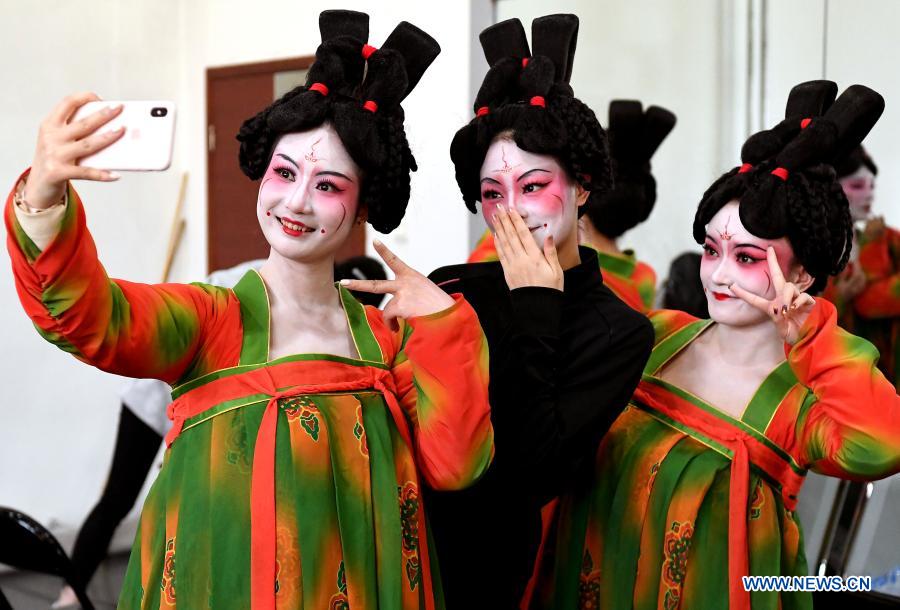 Dancers take selfies at Zhengzhou Song and Dance Theater in Zhengzhou, central China's Henan Province, Feb. 20, 2021. Fourteen dancers from Zhengzhou Song and Dance Theater have been very busy since the dancing they performed went viral online. The performance, named Banquet of Tang Palace, was staged at the Spring Festival gala of Henan Province. Brilliantly choreographed and acted, the dancing has almost brought ancient dancing figurines of the Tang Dynasty (618-907) alive. The performance Banquet of Tang Palace, inspired by the dancing figurines displayed at a museum, tells a story about the life of female musicians during the Tang Dynasty. 