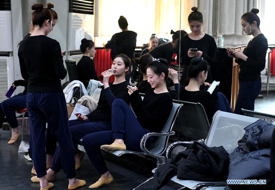 Dancers take a break at Zhengzhou Song and Dance Theater in Zhengzhou, central China's Henan Province, Feb. 20, 2021. Fourteen dancers from Zhengzhou Song and Dance Theater have been very busy since the dancing they performed went viral online. The performance, named Banquet of Tang Palace, was staged at the Spring Festival gala of Henan Province. Brilliantly choreographed and acted, the dancing has almost brought ancient dancing figurines of the Tang Dynasty (618-907) alive. The performance Banquet of Tang Palace, inspired by the dancing figurines displayed at a museum, tells a story about the life of female musicians during the Tang Dynasty. 