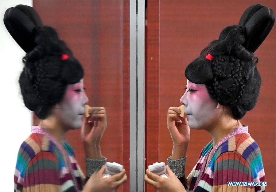 A dancer puts on makeup at Zhengzhou Song and Dance Theater in Zhengzhou, central China's Henan Province, Feb. 20, 2021. Fourteen dancers from Zhengzhou Song and Dance Theater have been very busy since the dancing they performed went viral online. The performance, named Banquet of Tang Palace, was staged at the Spring Festival gala of Henan Province. Brilliantly choreographed and acted, the dancing has almost brought ancient dancing figurines of the Tang Dynasty (618-907) alive. The performance Banquet of Tang Palace, inspired by the dancing figurines displayed at a museum, tells a story about the life of female musicians during the Tang Dynasty. 