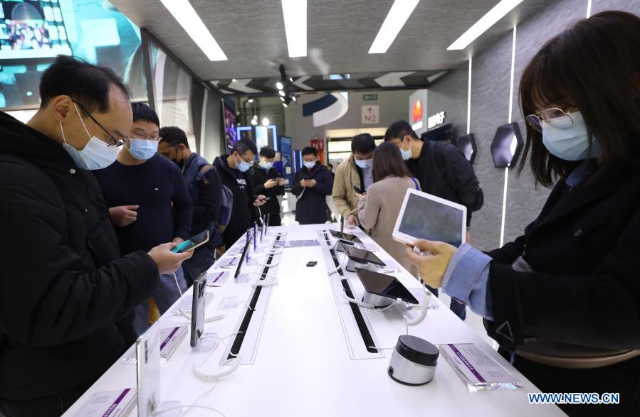 Visitors try mobile phones and tablets during the Mobile World Congress (MWC) Shanghai 2021 in east China's Shanghai, Feb 23, 2021. The MWC Shanghai 2021 opened on Tuesday. (Xinhua/Fang Zhe)