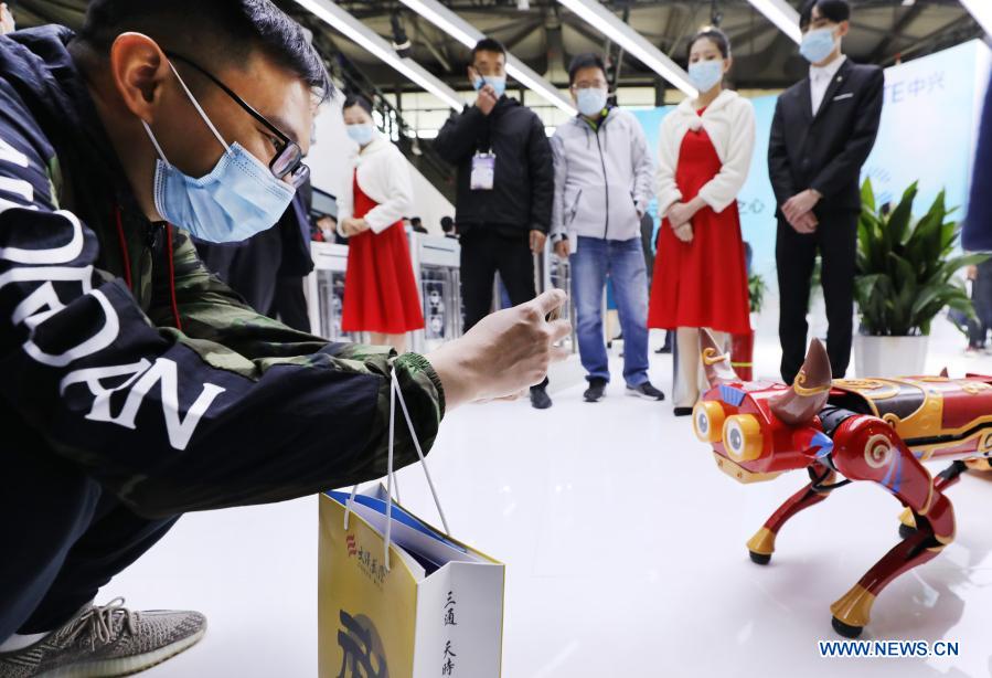 A visitor takes photos of a robot during the Mobile World Congress (MWC) Shanghai 2021 in east China's Shanghai, Feb 23, 2021. The MWC Shanghai 2021 opened on Tuesday. (Xinhua/Fang Zhe)