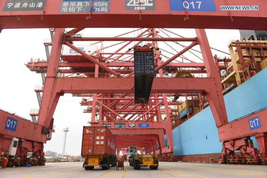 The crane lifts a container at the Ningbo Zhoushan Port in Ningbo, east China's Zhejiang Province, March 3, 2021. Both cargo and container throughput of Ningbo Zhoushan Port registered year-on-year growth of 4.7 percent and 4.3 percent respectively in 2020. The port saw its cargo throughput reach 1.172 billion tons while the container throughput achieved 28.72 million twenty-foot equivalent units (TEUs) last year. (Xinhua/Weng Xinyang)