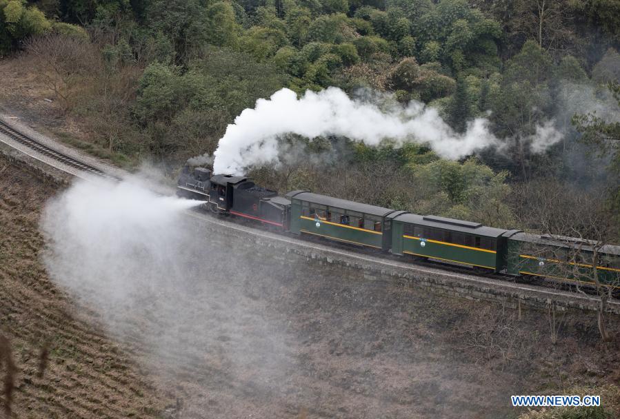 A train runs on a narrow gauge railway in Qianwei County, southwest China's Sichuan Province, March 2, 2021. The old-fashioned steam train, running on a narrow gauge railway in Qianwei County, serves mainly in sightseeing. As increasing number of tourists visit the county in recent years, the train itself has become an attraction providing a journey of reminiscence. (Xinhua/Jiang Hongjing)