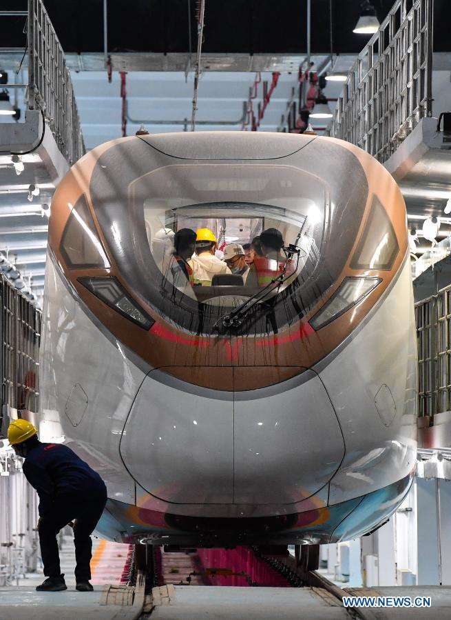 Technicians taking part in the hot-running test perform the final check of a train of the Guangzhou Metro Line 18 before the test in Guangzhou, south China's Guangdong Province, March 3, 2021. The electric train, with a maximum designed speed of 160 km per hour, carried out the first hot-running test in the small hours of Thursday morning, in order to conduct a comprehensive inspection of the subway power supply, signal, communication, line, and electromechanical system of the line. (Xinhua/Liu Dawei)