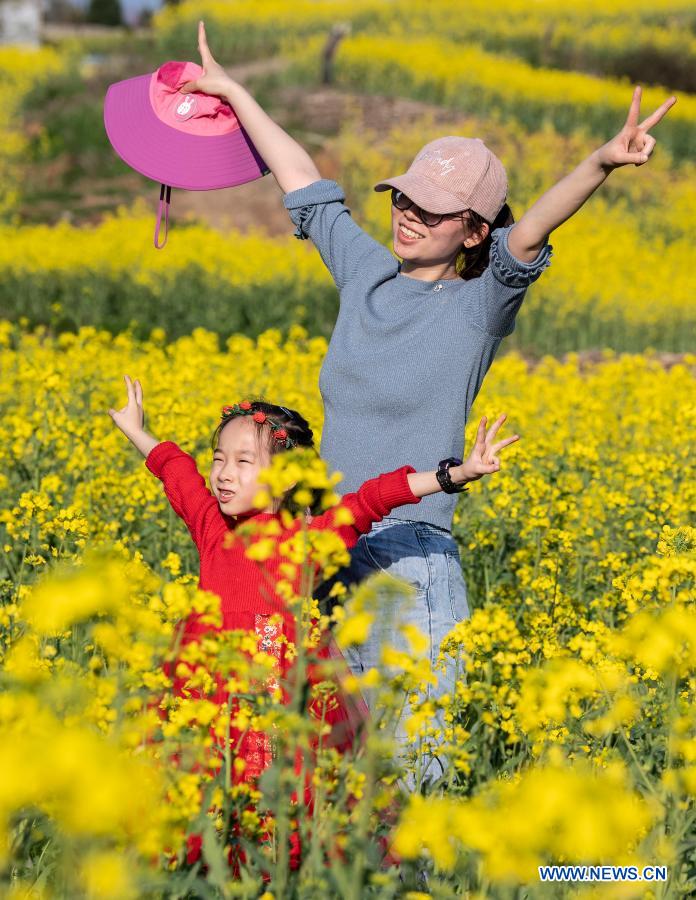 People pose for photos in the cole flower fields in Hanzhong, northwest China's Shaanxi Province, March 13, 2021. (Xinhua/Tao Ming)