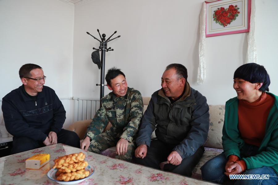 Gu Zhengli (2nd R) learns about the water supply condition at a herdsman household in Dahe Township, Yugu Autonomous County of Sunan, northwest China's Gansu Province, March 20, 2021. Gu Zhengli, 59, has been working at the frontline of Tanggaer water conservancy project in Dahe Township for 42 years, safeguarding the safety of the drinking water for local people and livestock. As the annual rainfall in the town is only 150 to 300 millimeters, Tanggaer water conservancy project is literally the lifeline for local herdsmen. Every morning, Gu gets up early and operates a pump to move water from the pumping station at the foot of the mountain to a reservoir at the top. Then he climbs to the top of the mountain at about 7 o'clock and opens the valve, letting the water in the reservoir flow to each water supply point through 7 pipelines. After that, he rides a motorcycle to 52 water supply points to check if everything runs well. In the past 42 years, Gu has been working like this. Local herdsmen always see him busy on the way along the water conservancy project. Thanks to the efforts of Gu and his colleagues, people in the area now can not only enjoy much safer water but also achieve a balance between grass and livestock ahead of schedule. At a drinking well along the water conservancy project, local herdsmen wrote a sign which says 
