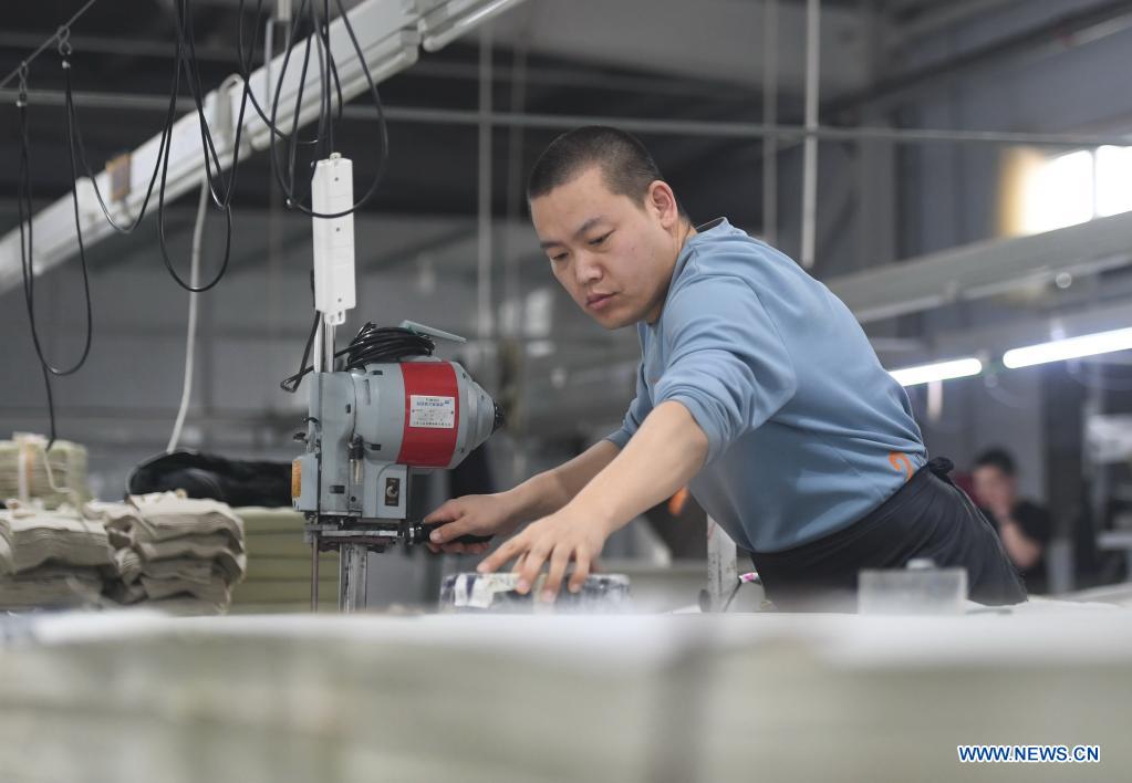 An employee works in a garment factory in Nanhe District of Xingtai City, north China's Hebei Province, March 28, 2021. The local government has been taking measures to build up a variety of platforms in an effort to provide job opportunities for local villagers. (Xinhua/Zhu Xudong)