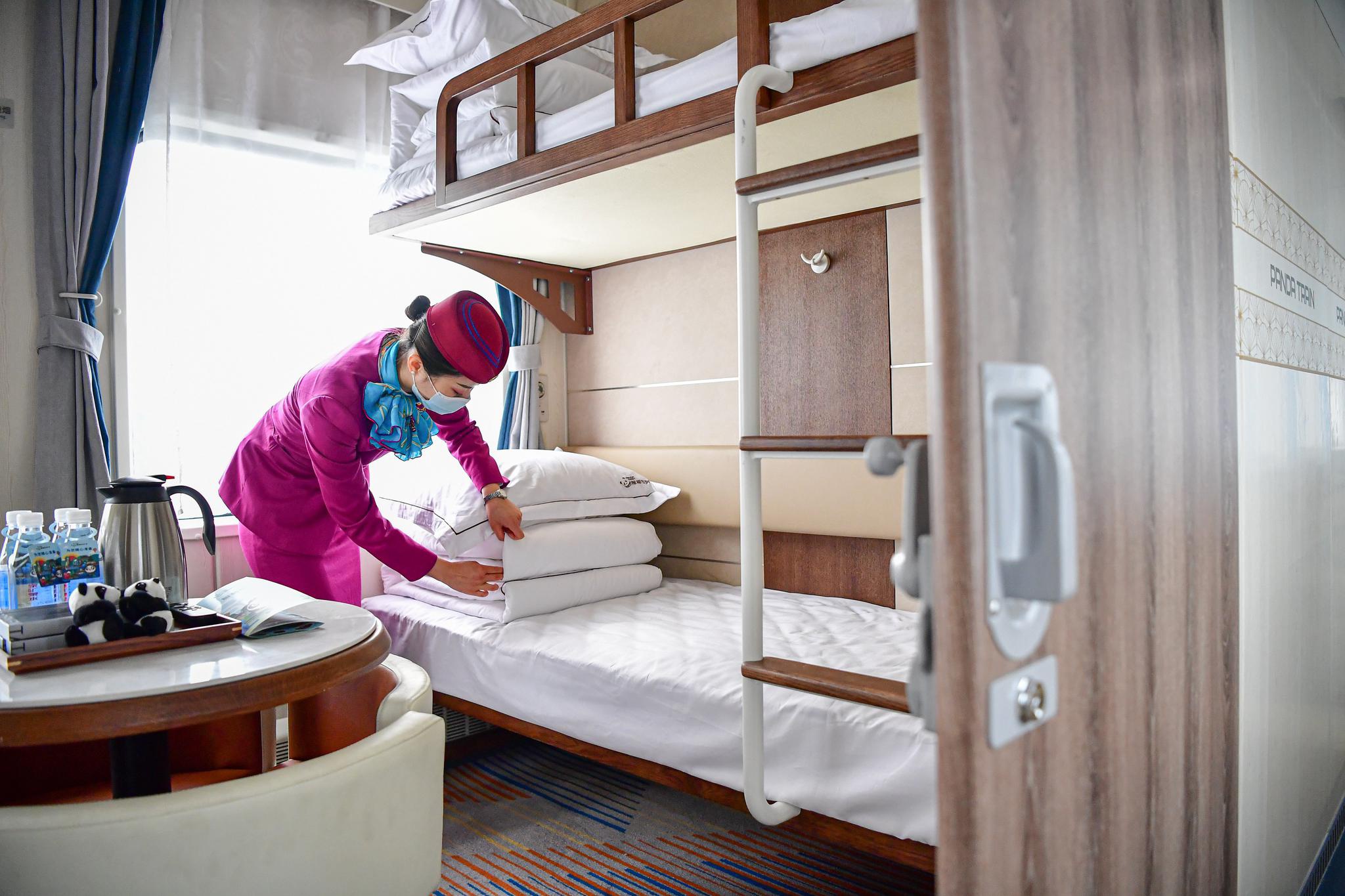 列车员在"熊猫专列"的四人软卧车厢整理卧具.
