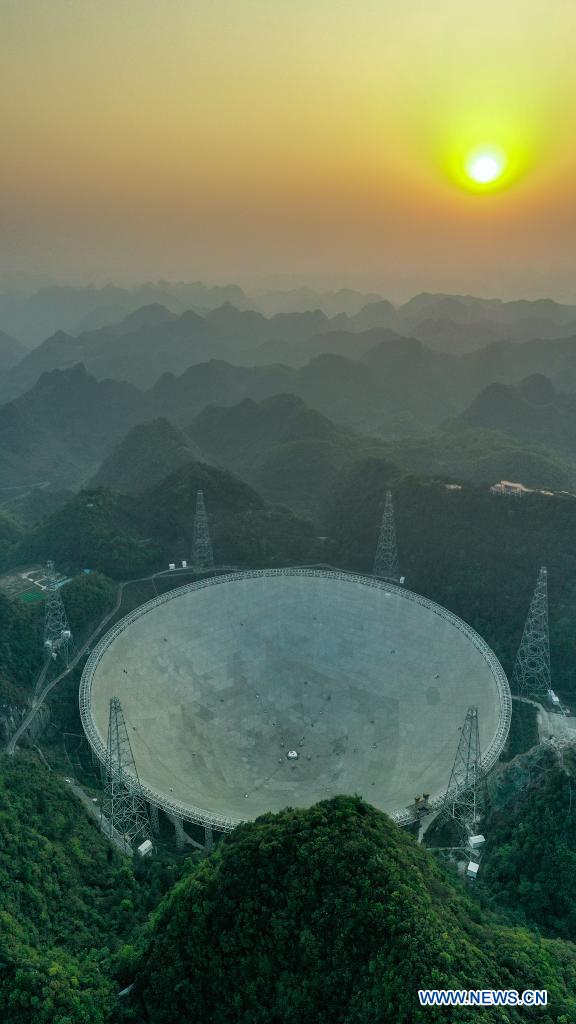 Aerial photo taken on March 29, 2021 shows China's Five-hundred-meter Aperture Spherical Radio Telescope (FAST) under maintenance at sunset in southwest China's Guizhou Province. China's FAST officially opened to the world starting Wednesday. (Xinhua/Ou Dongqu)