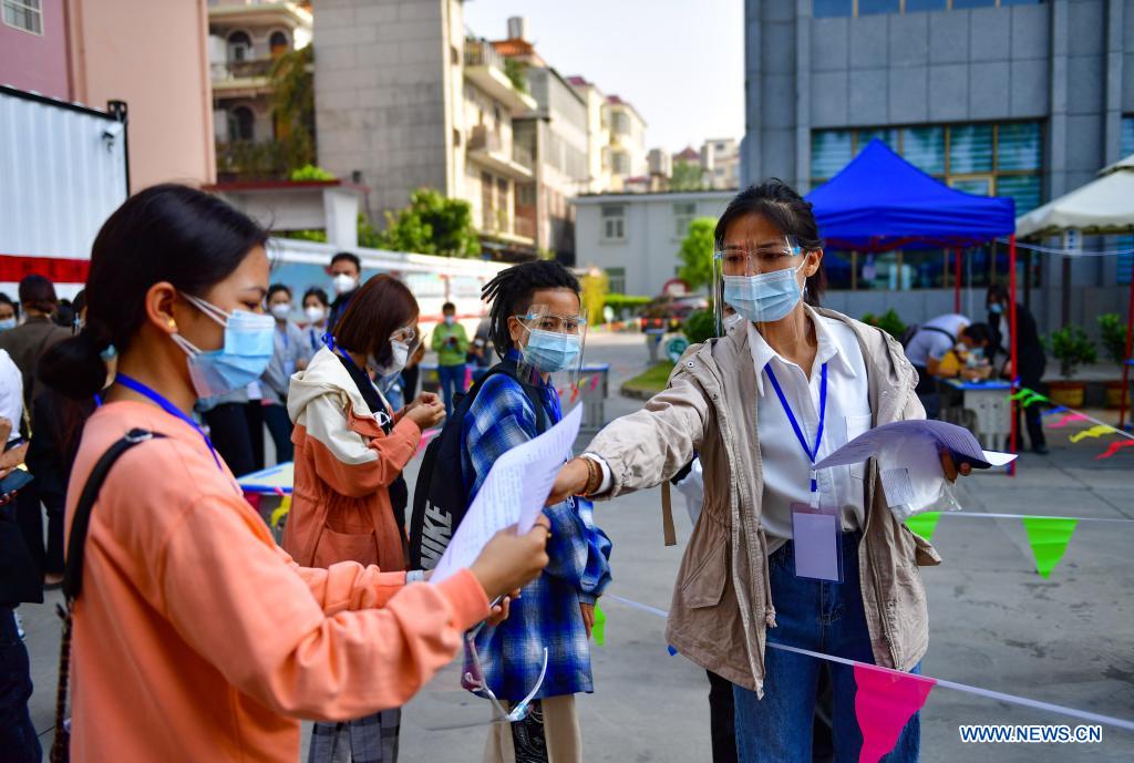 A Burmese language translator hands out forms to other volunteers at the management center for foreign nationals in Ruili City, southwest China's Yunnan Province, April 3, 2021. Frontline medical workers, epidemic prevention and control personnel, border patrol personnel and volunteers from all walks of life work hard to control the spread of the novel coronavirus after new cluster infections were reported late March. (Xinhua/Chen Xinbo)