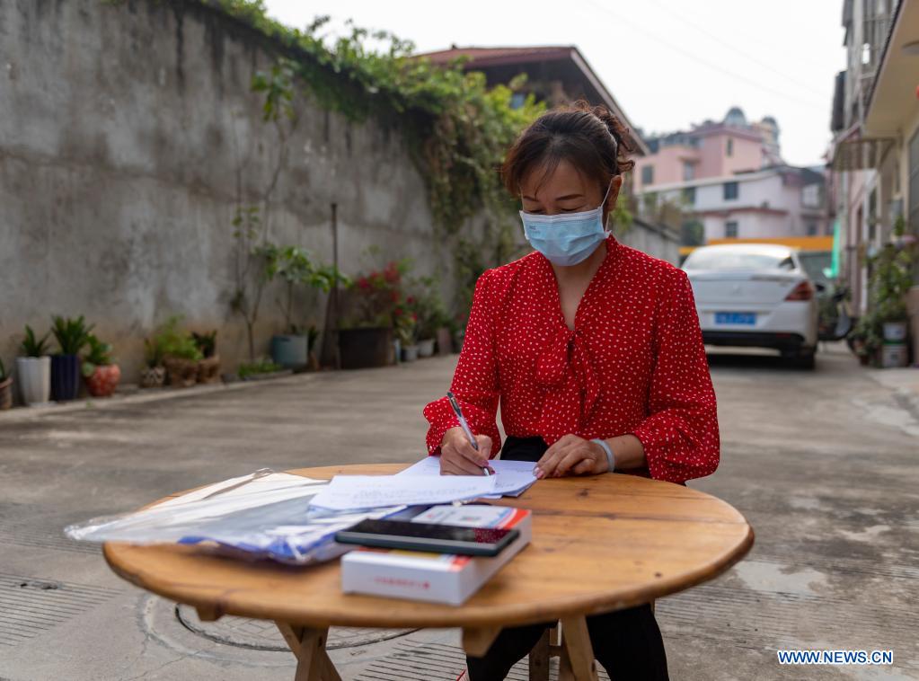 A staff member works at the entrance of a community in Ruili City, southwest China's Yunnan Province, April 5, 2021. Frontline medical workers, epidemic prevention and control personnel, border patrol personnel and volunteers from all walks of life work hard to control the spread of the novel coronavirus after new cluster infections were reported late March. (Xinhua/Chen Xinbo)