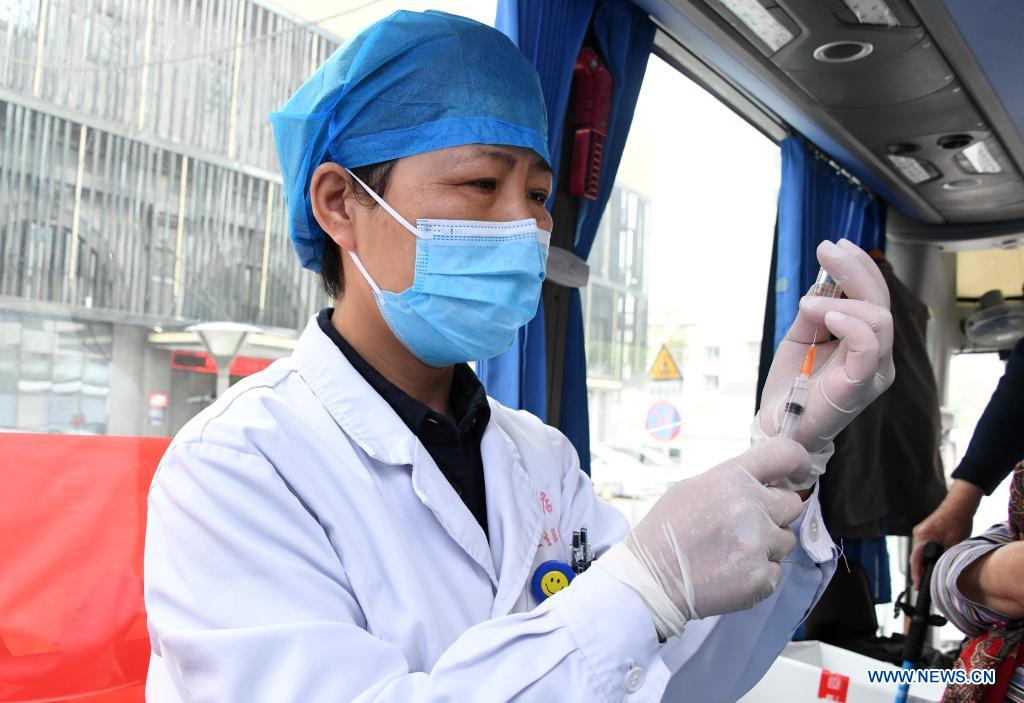 A medical worker prepares a dose of vaccine in a mobile vaccination vehicle in Haidian District of Beijing, capital of China, April 11, 2021. Beijing and Shanghai have deployed mobile vaccination vehicles in downtown areas. The bus-like facilities, equipped with vaccination stations, medical refrigerators and first-aid equipment, have been rolled out to save time and improve inoculation efficiency. (Xinhua/Ren Chao)