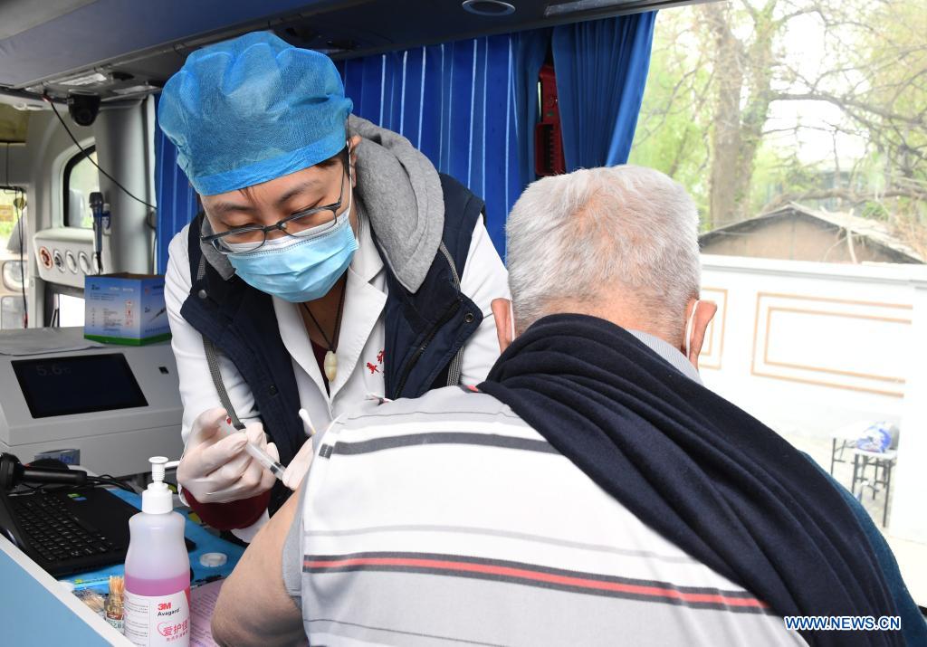 A medical worker injects a local resident with a dose of COVID-19 vaccine in a mobile vaccination vehicle in Haidian District of Beijing, capital of China, April 11, 2021. Beijing and Shanghai have deployed mobile vaccination vehicles in downtown areas. The bus-like facilities, equipped with vaccination stations, medical refrigerators and first-aid equipment, have been rolled out to save time and improve inoculation efficiency. (Xinhua/Ren Chao)