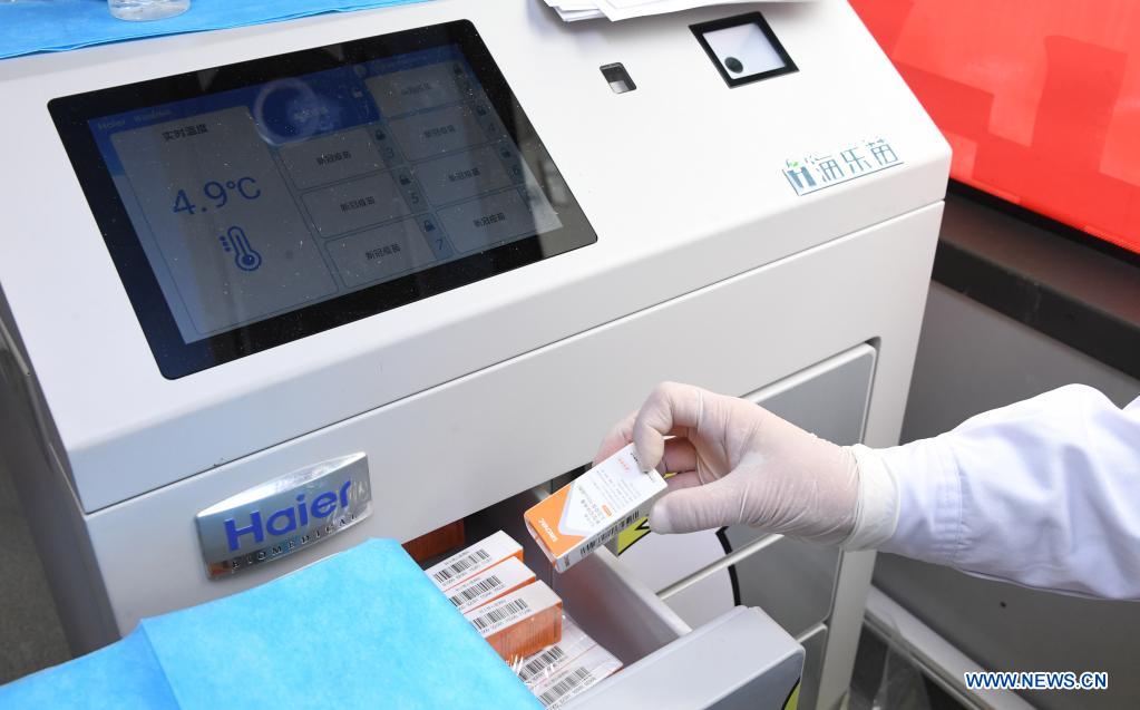 A medical worker take out a dose of vaccine from a refrigerator in a mobile vaccination vehicle in Haidian District of Beijing, capital of China, April 11, 2021. Beijing and Shanghai have deployed mobile vaccination vehicles in downtown areas. The bus-like facilities, equipped with vaccination stations, medical refrigerators and first-aid equipment, have been rolled out to save time and improve inoculation efficiency. (Xinhua/Ren Chao)