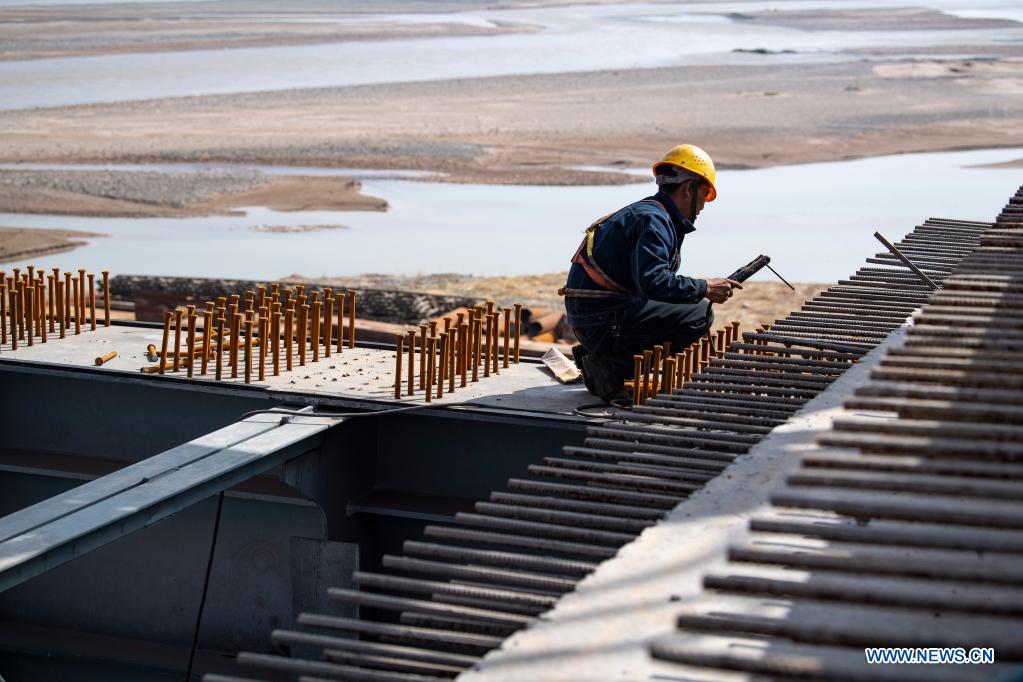 A worker works at the construction site of Zhenluo Yellow River Bridge in Zhongwei City, northwest China's Ningxia Hui Autonomous Region, April 11, 2021. The 1,289-meter-long Zhenluo Yellow River Bridge in the Ningxia section of the Wuhai-Maqin expressway finished its final stage for closure Sunday. (Xinhua/Feng Kaihua)