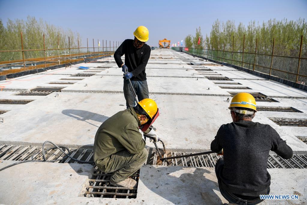 Workers are busy at the construction site of Zhenluo Yellow River Bridge in Zhongwei City, northwest China's Ningxia Hui Autonomous Region, April 11, 2021. The 1,289-meter-long Zhenluo Yellow River Bridge in the Ningxia section of the Wuhai-Maqin expressway finished its final stage for closure Sunday. (Xinhua/Feng Kaihua)