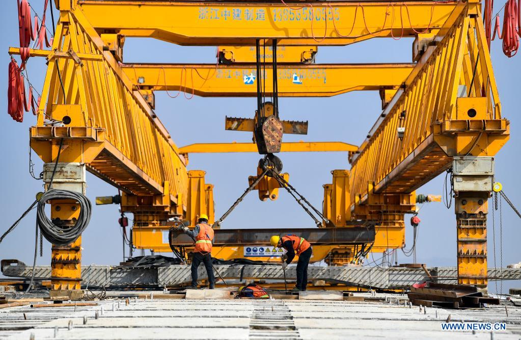Workers are busy at the construction site of Zhenluo Yellow River Bridge in Zhongwei City, northwest China's Ningxia Hui Autonomous Region, April 11, 2021. The 1,289-meter-long Zhenluo Yellow River Bridge in the Ningxia section of the Wuhai-Maqin expressway finished its final stage for closure Sunday. (Xinhua/Feng Kaihua)
