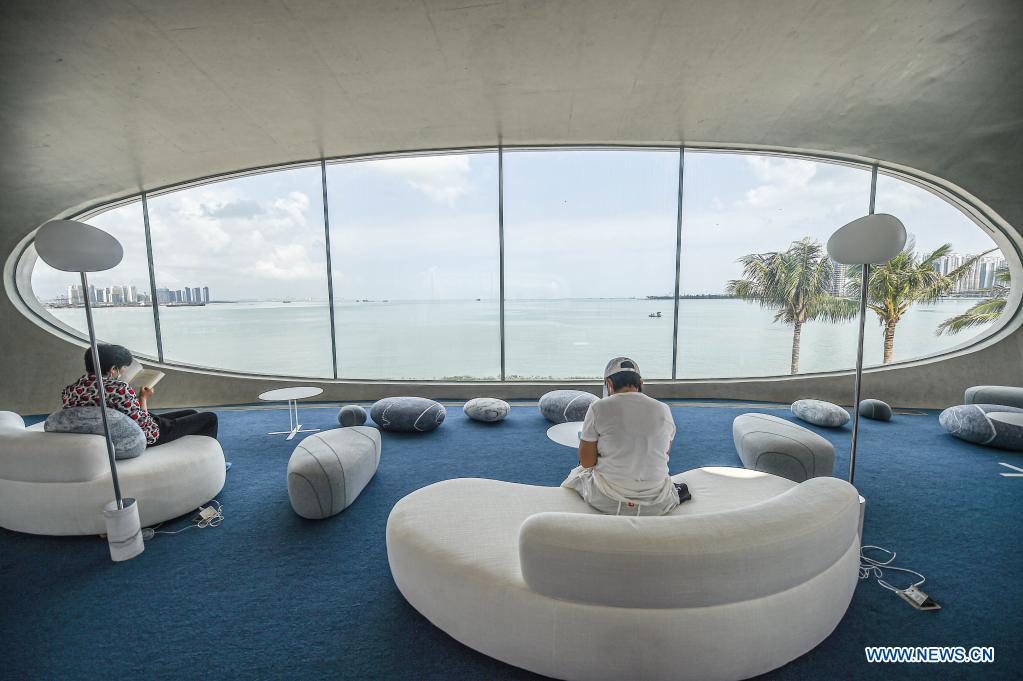 People read at the Wormhole Library in the Haikou Bay in Haikou, capital city of south China's Hainan Province on April 13, 2021. The Wormhole Library, designed as a landmark building in the Haikou Bay, opened to public on Tuesday. (Xinhua/Pu Xiaoxu)