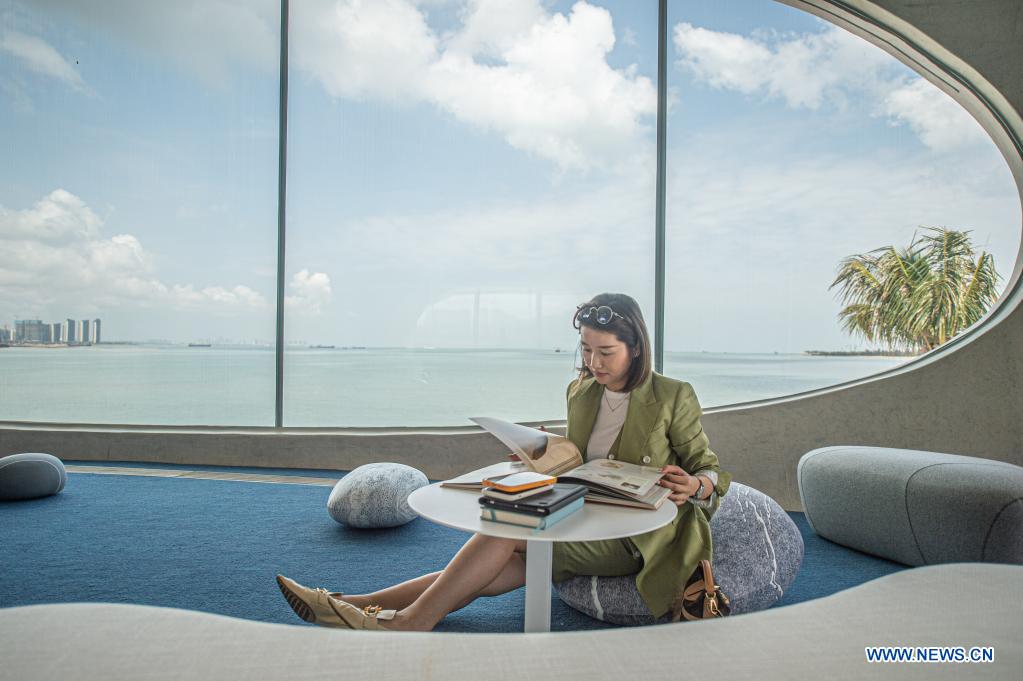 A reader is seen at the Wormhole Library in the Haikou Bay in Haikou, capital city of south China's Hainan Province on April 13, 2021. The Wormhole Library, designed as a landmark building in the Haikou Bay, opened to public on Tuesday. (Xinhua/Pu Xiaoxu)