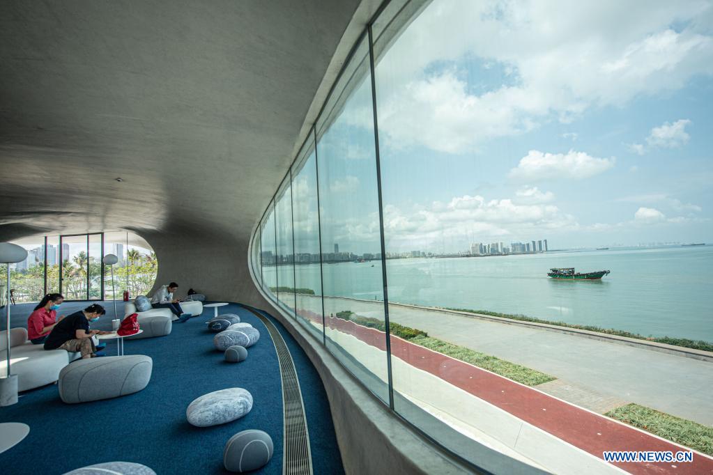 People read and rest at the Wormhole Library in the Haikou Bay in Haikou, capital city of south China's Hainan Province on April 13, 2021. The Wormhole Library, designed as a landmark building in the Haikou Bay, opened to public on Tuesday. (Xinhua/Pu Xiaoxu)