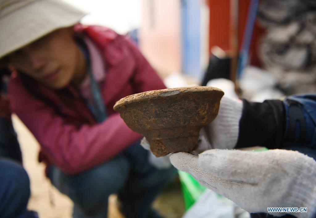 A staff member shows and explains an unearthed cultural relic in Anyang, central China's Henan Province, April 8, 2021. Anyang is listed as one of the 