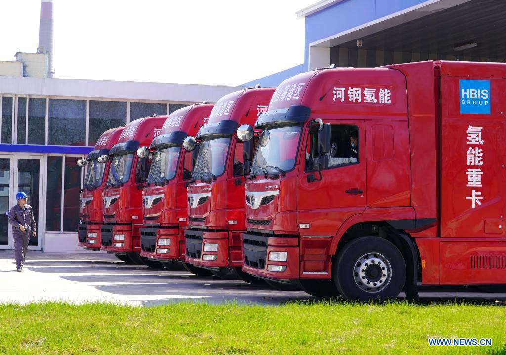 A worker walks past five newly introduced hydrogen-powered heavy-duty trucks in the Tangshan Haigang Economic Development Zone of Tangshan, north China's Hebei Province, April 14, 2021. Five hydrogen-powered heavy-duty trucks have been introduced on Wednesday by the Tangshan Haigang Economic Development Zone. The fleet of trucks are among the zone's first attempts to optimize its industrial structure and energy consumption by gradually replacing diesel fuel with the more eco-friendly hydrogen power cells. (Xinhua/Yang Shiyao)